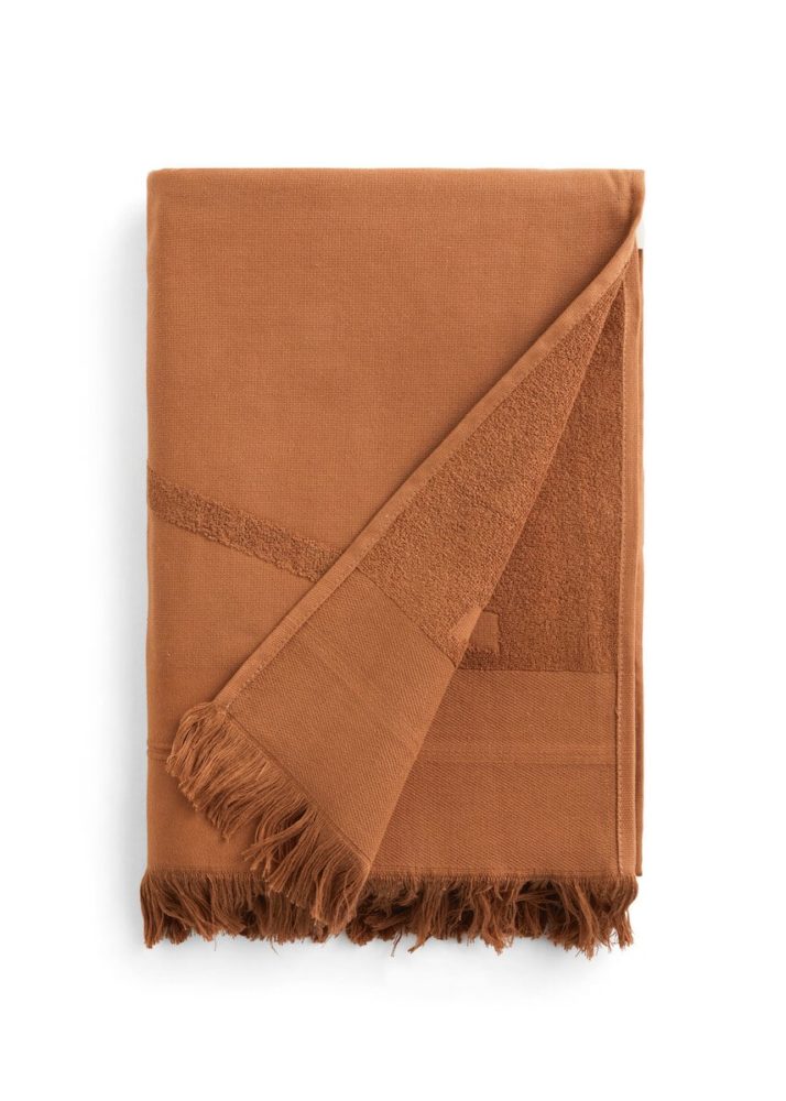 Folded brown WAY beach towel with woven front and terry back and fringes
