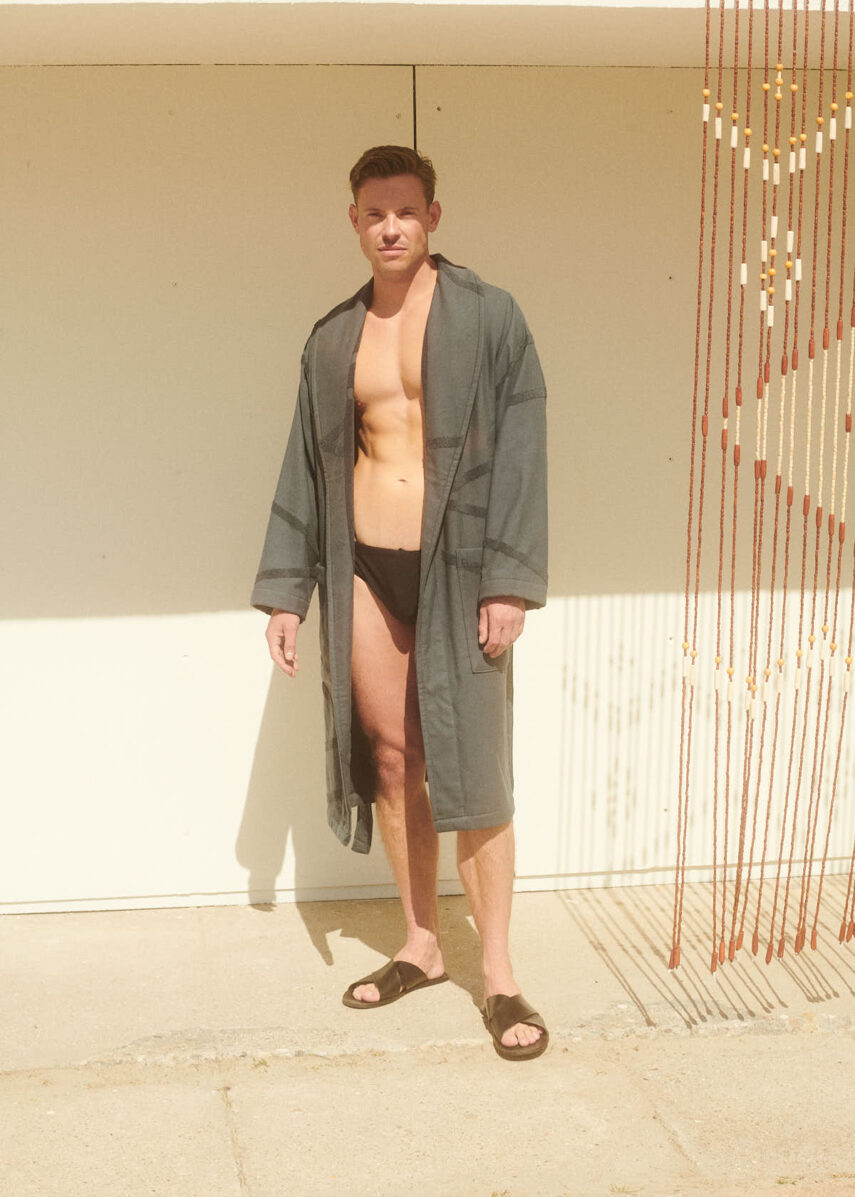 Marin Bathrobe in charcoal from WAY on a guy at the beach wearing speedos