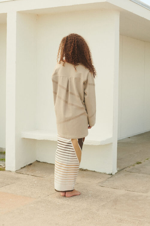 Girl on beach wearing WAy mala kaftan in stone