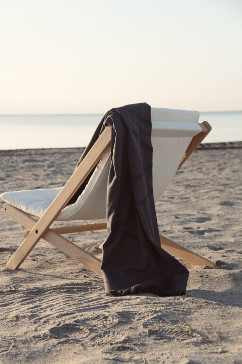WAY beach towel in dark grey on beach chair by the ocean