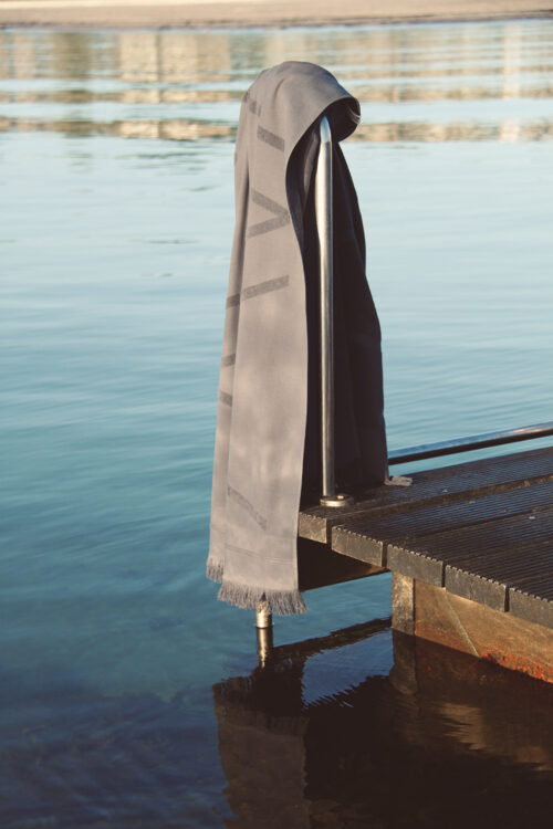 WAY beach towel in dark grey charcoal hanging wby the blue ocean