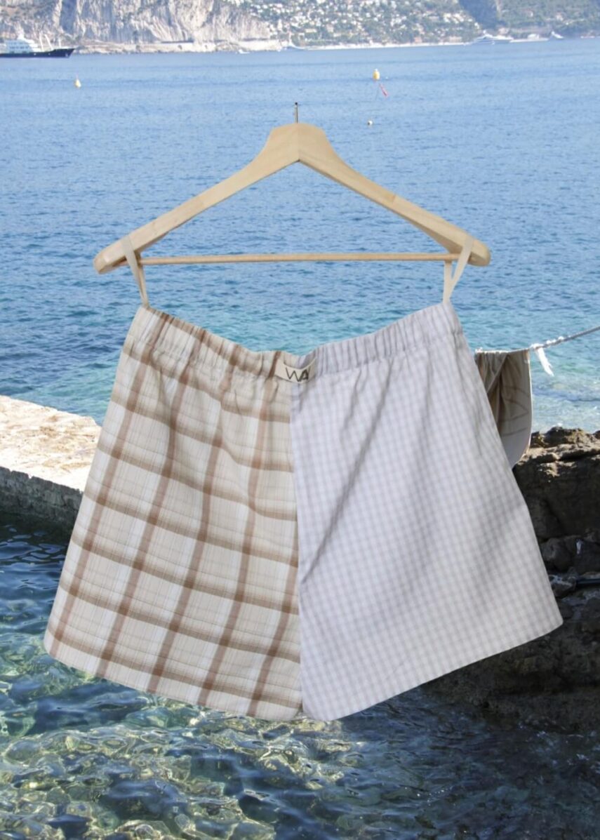 Upcycled blue striped SUN Shorts from WAY collaboration with Salvation Army with ocean back ground