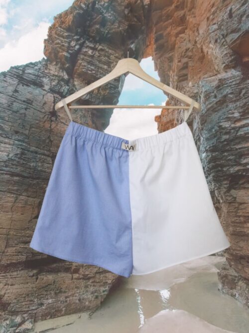 Upcycled blue striped SUN Shorts from WAY collaboration with Salvation Army with ocean back ground