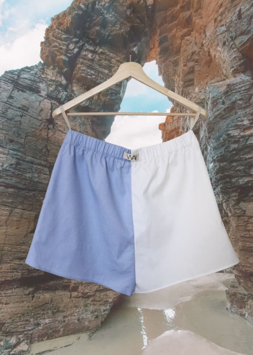 Upcycled blue striped SUN Shorts from WAY collaboration with Salvation Army with ocean back ground
