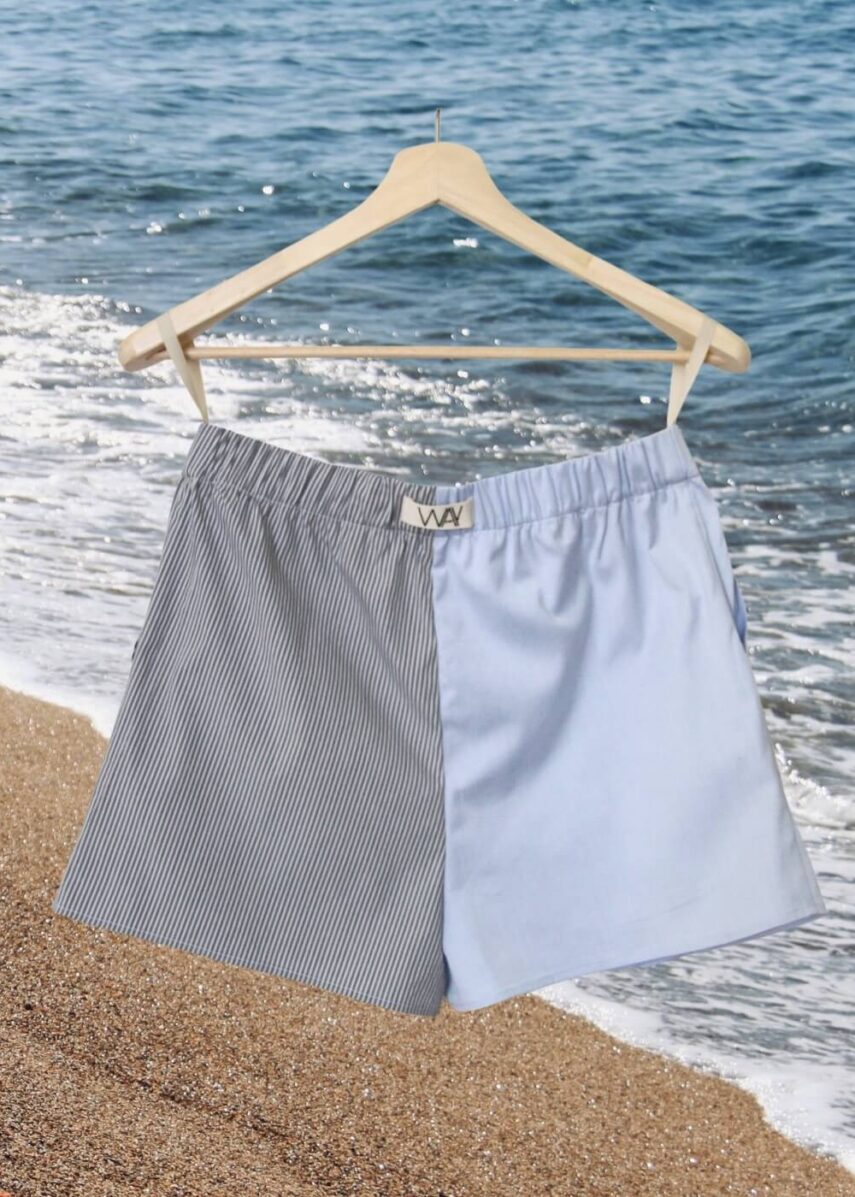 Upcycled blue striped SUN Shorts from WAY collaboration with Salvation Army with ocean back ground