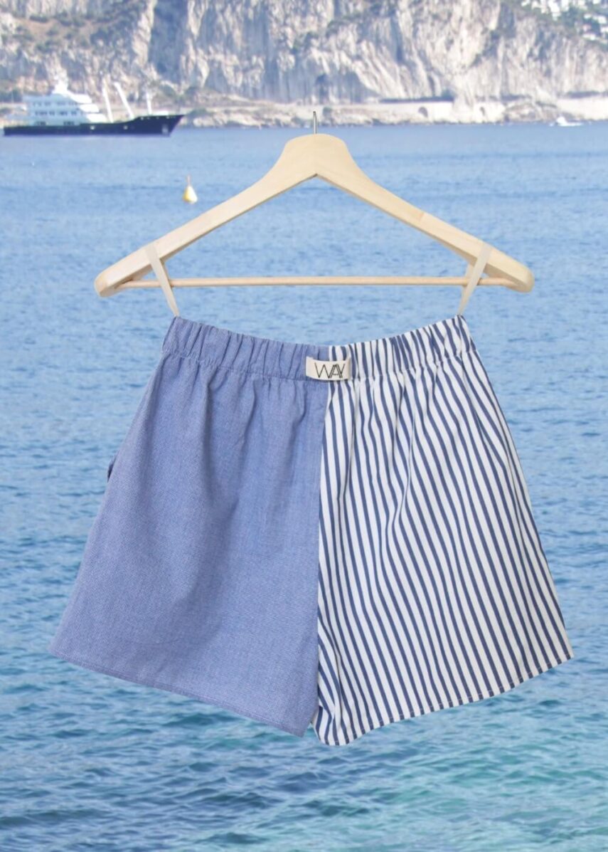 Upcycled blue striped SUN Shorts from WAY collaboration with Salvation Army with ocean back ground