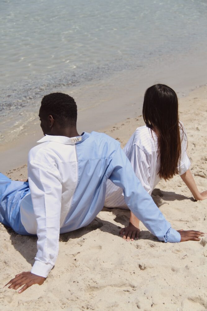 Couple sitting on the beach in shirts from WAY
