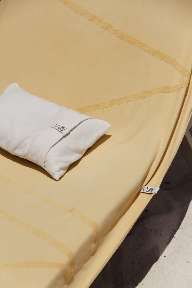 WAY Beach pillow in Shell on yellow WAY logo beach towel on a sunbed