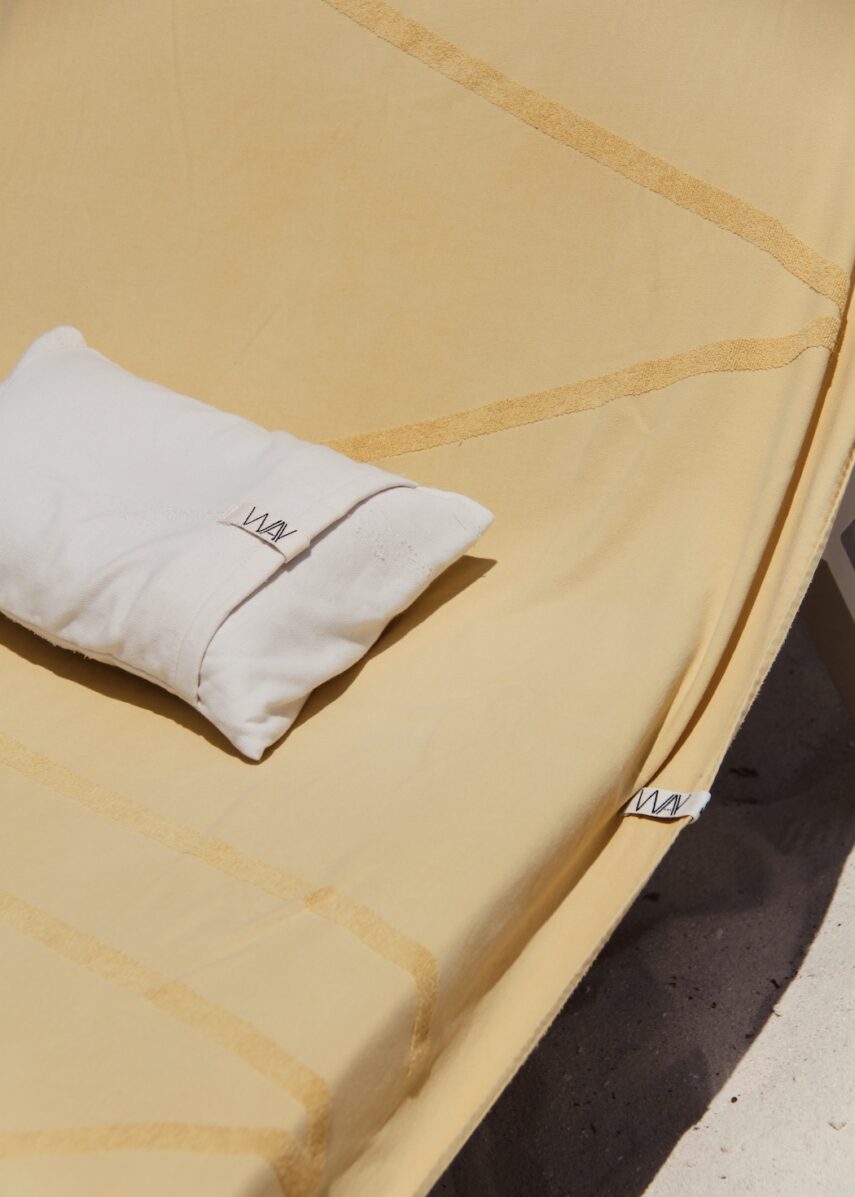 WAY Beach pillow in Shell on yellow WAY logo beach towel on a sunbed