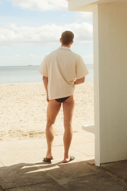 WAY Bilboa shirt in Sheel cream white from the back on a male model at the beach