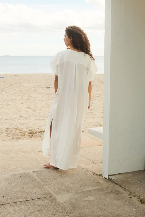 Girl at the beach wearing Cala kaftan dress in white shell by WAY
