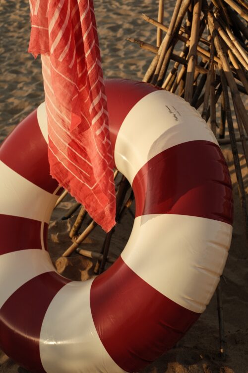Red pool float on the bach with red sarong in the sundown light
