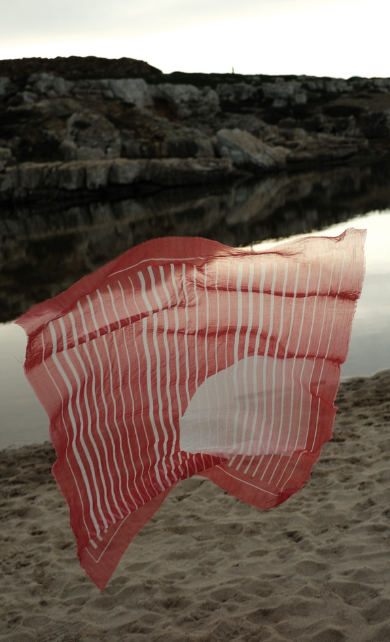 Red sarong in the wind by the beach by Petites Pommes