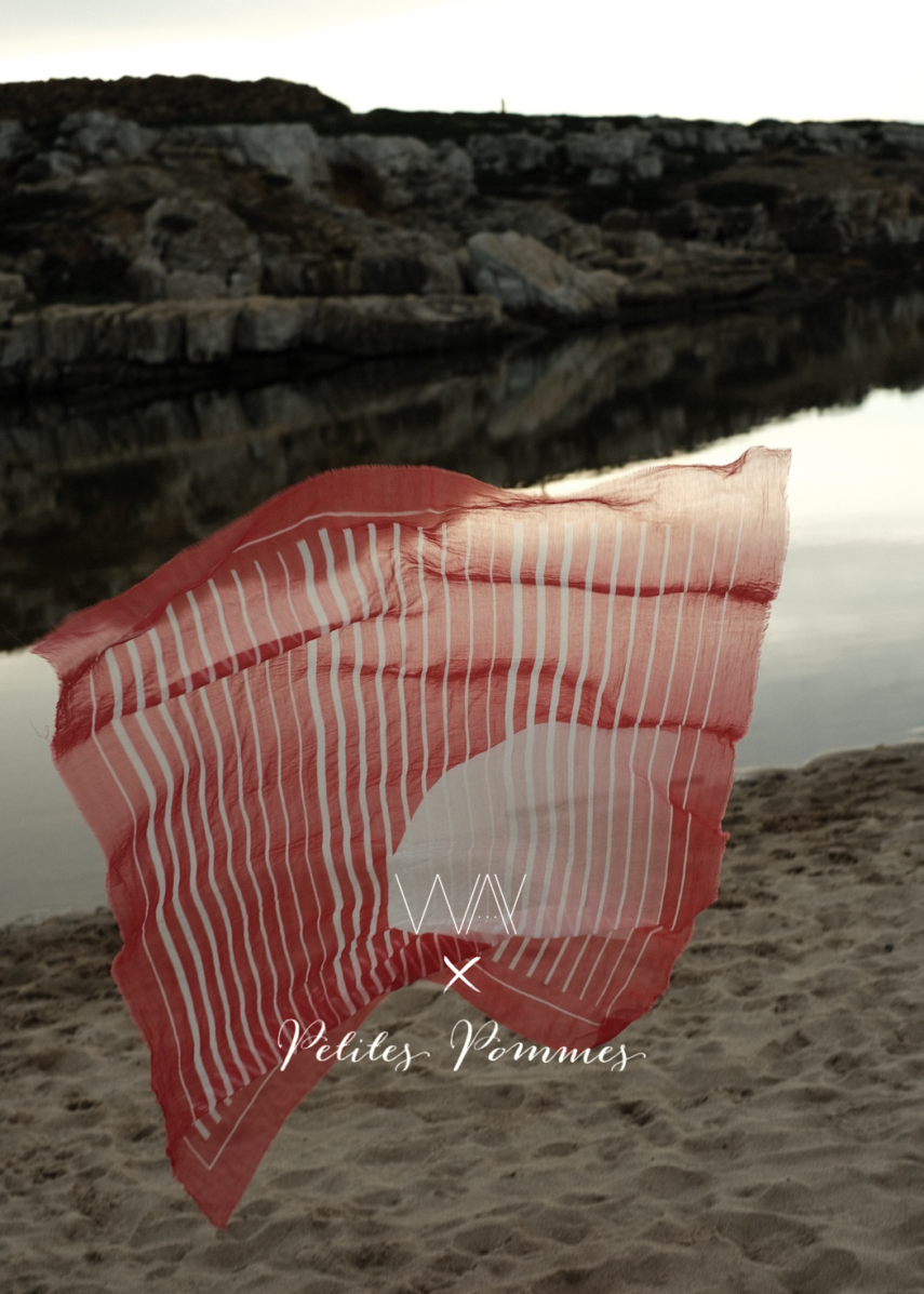 Red sarong floating in the air by the beach from petites pommes